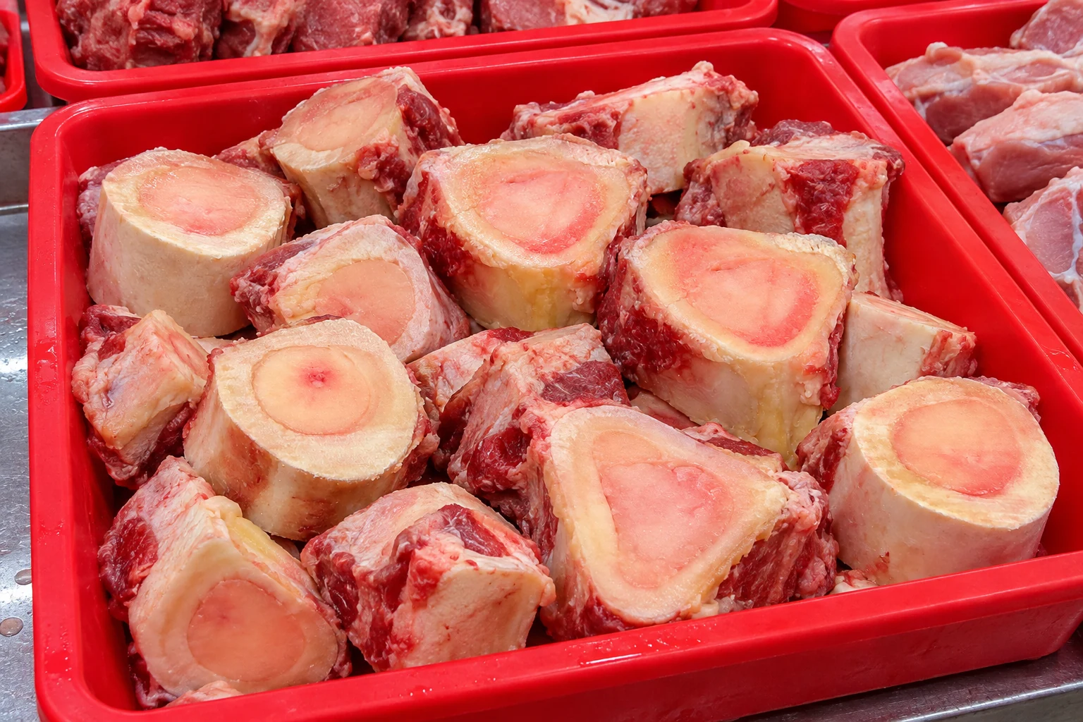 Illustration of cross-cut beef marrow bones in a red wet-market stall tray
